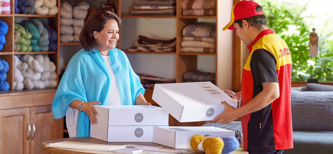 DHL courier reviewing shipping labels on boxes
