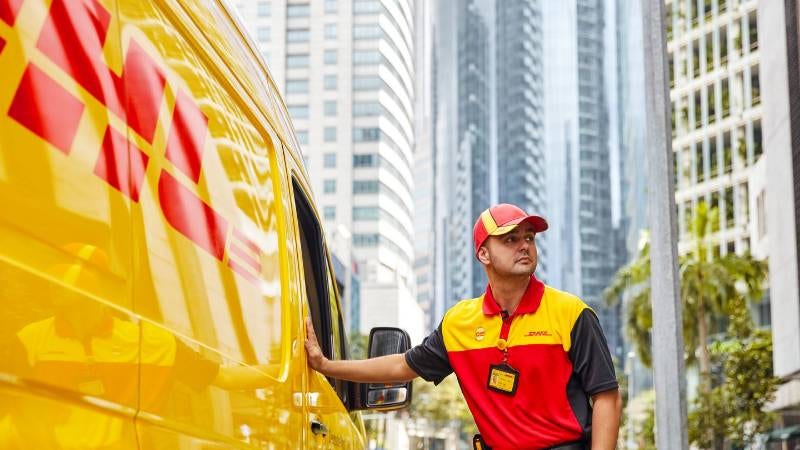 A DHL personnel delivering parcels as part of their courier services
