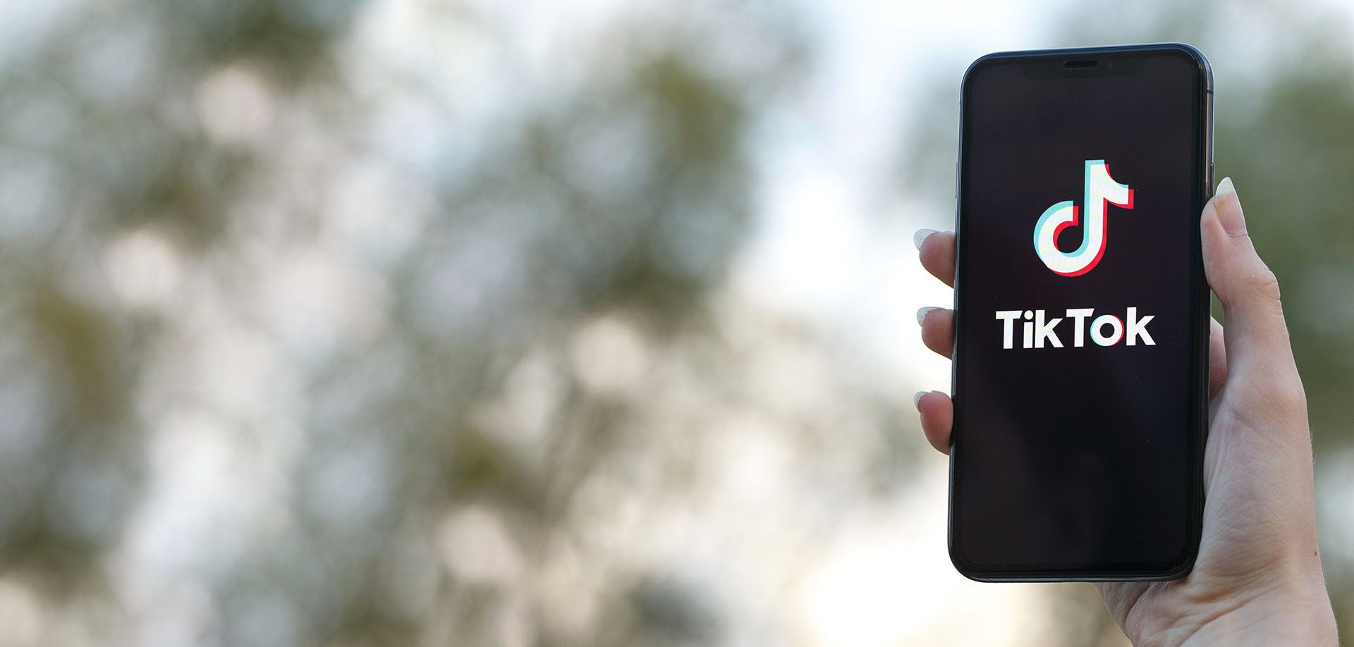 hand holding a mobile phone with tik tok logo on screen