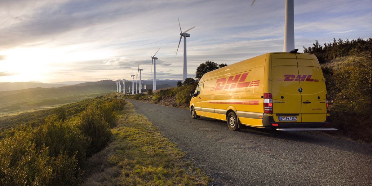DHL送货车在伴有风车的路上前进