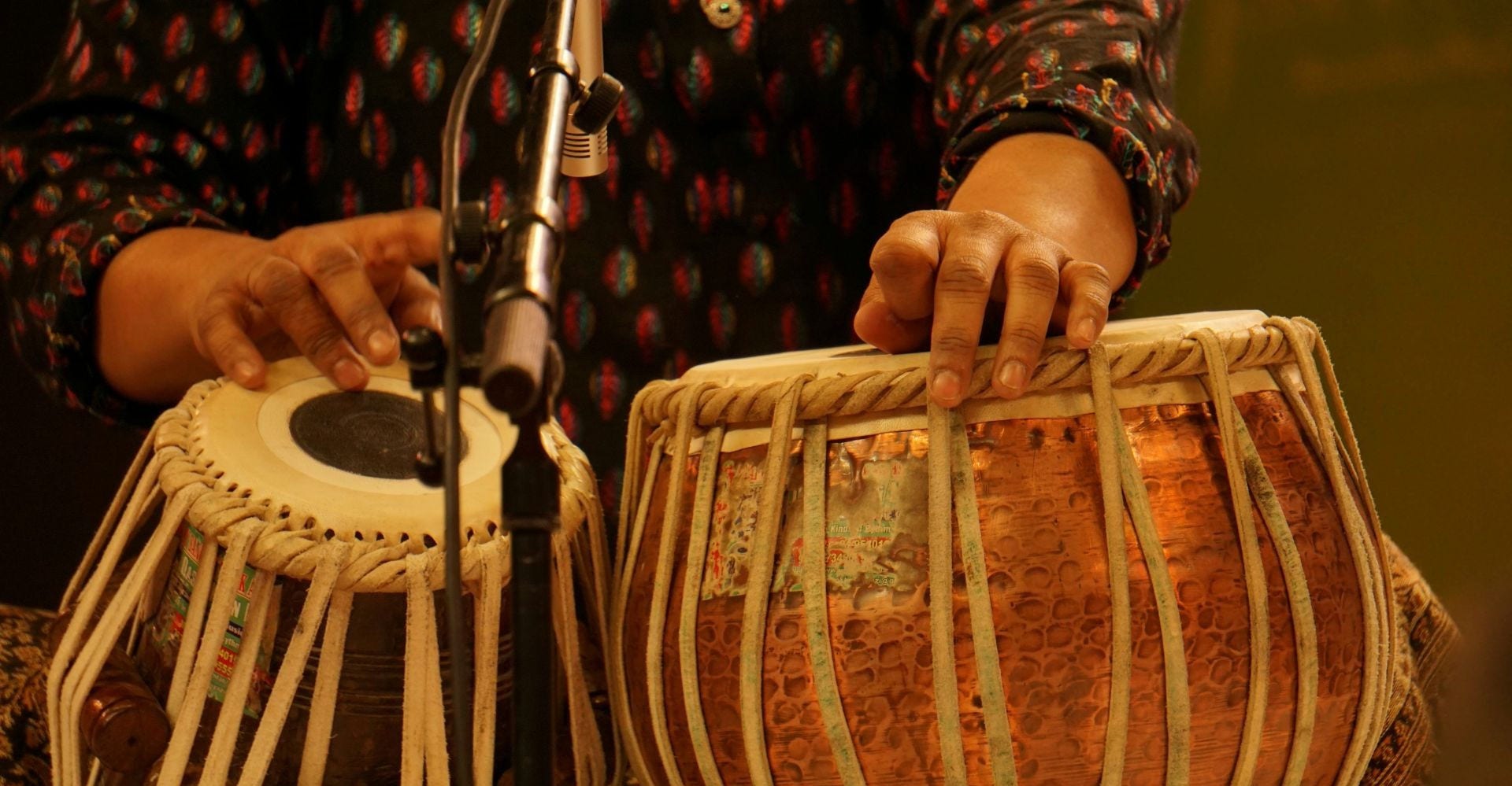a musician playing the tabla, an Indian percussion instrument, during a live performance.