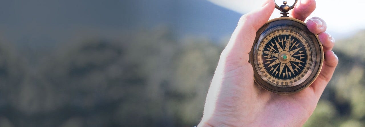 Hand holding a compass