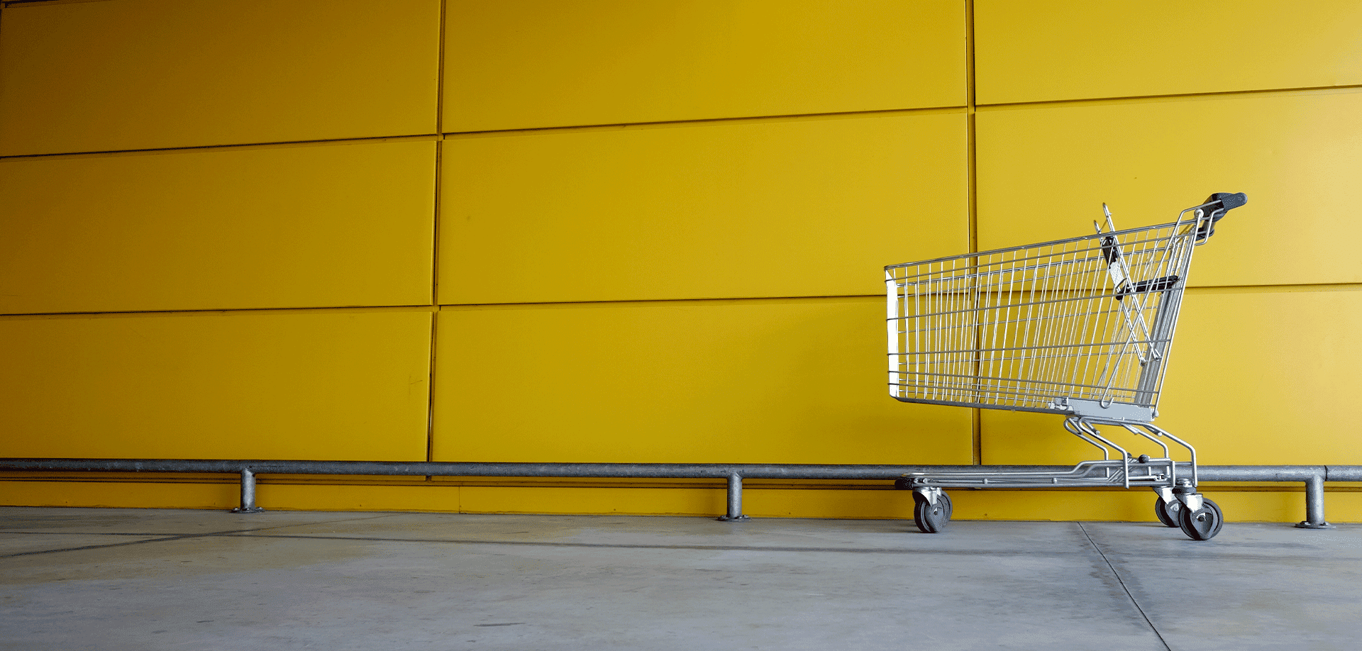 shopping cart against a yellow wall