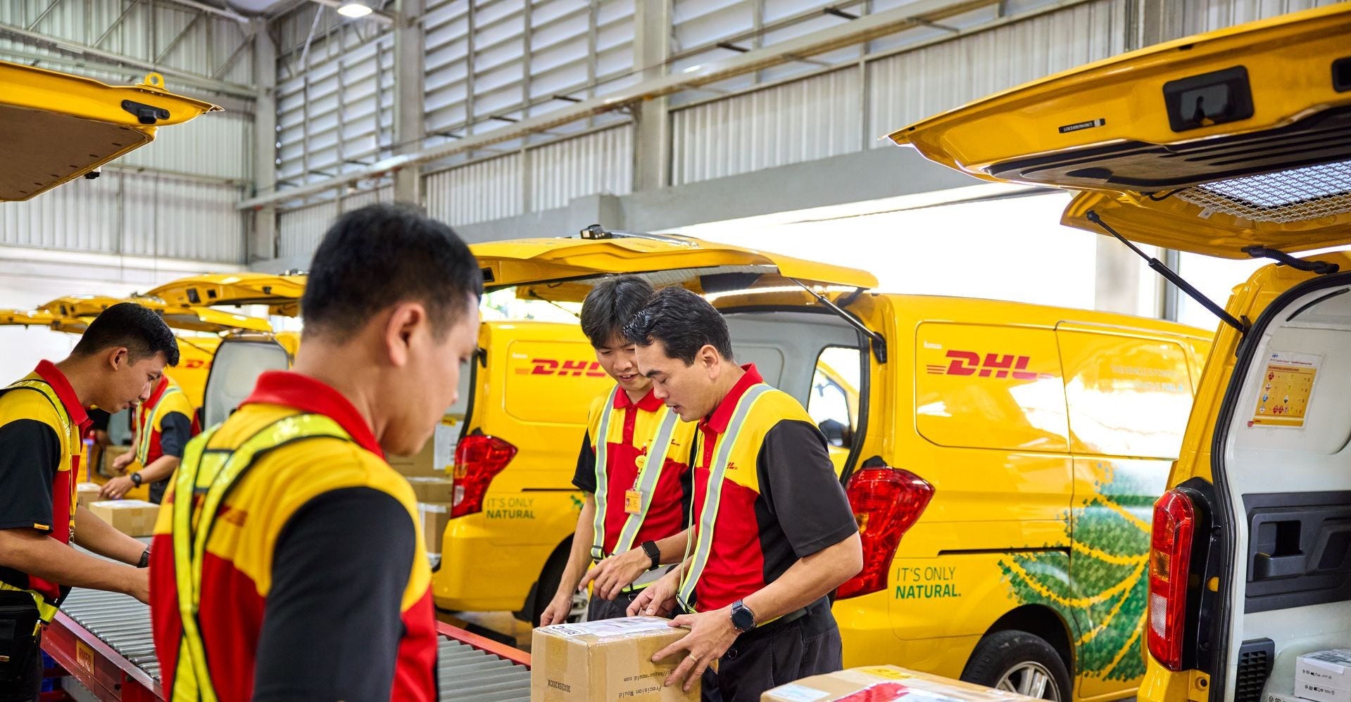 DHL Express employees sorting laptop packages