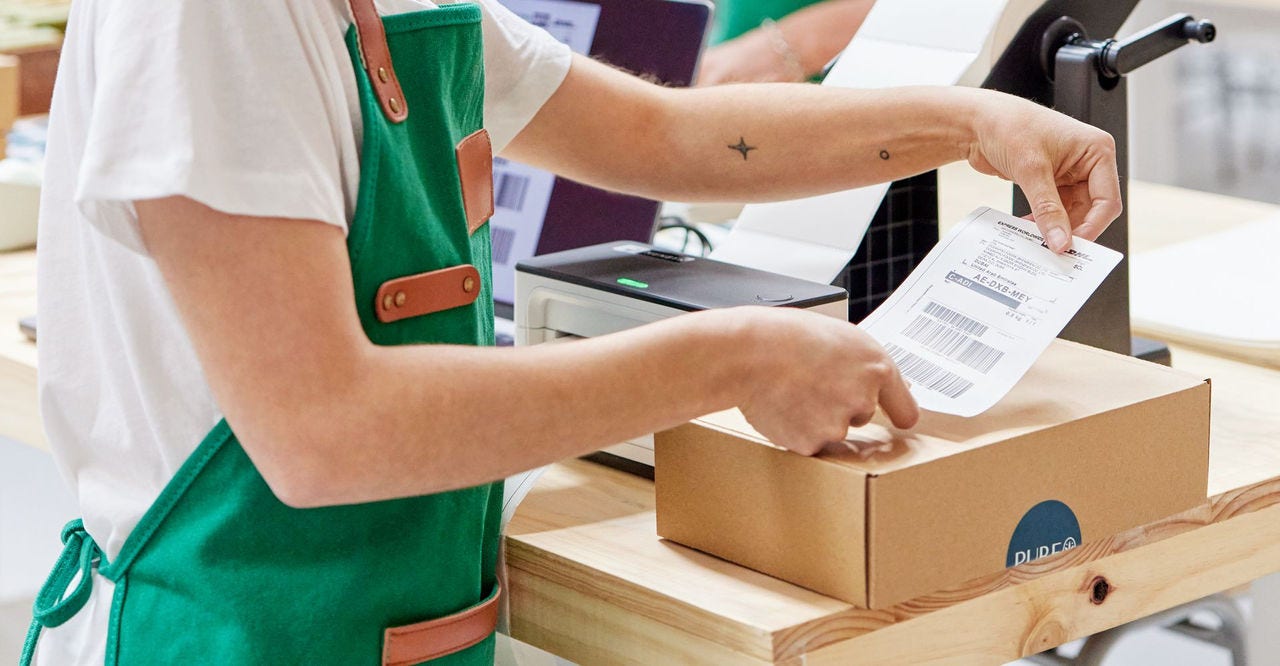 woman sticking a label on a parcel for shipping