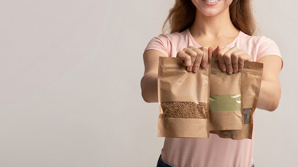 woman holding three brown packs