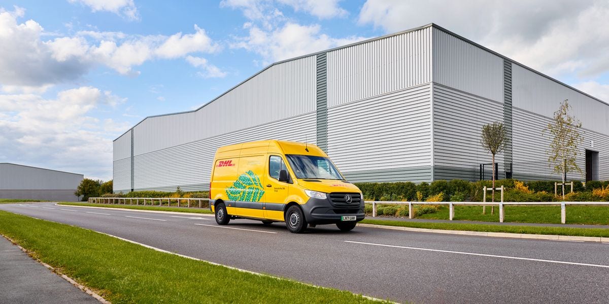 一辆DHL电动货车行驶在一家电子商务中心前的街道上