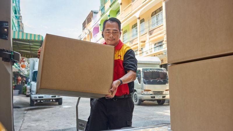 A DHL logistics employee preparing parcels for delivery