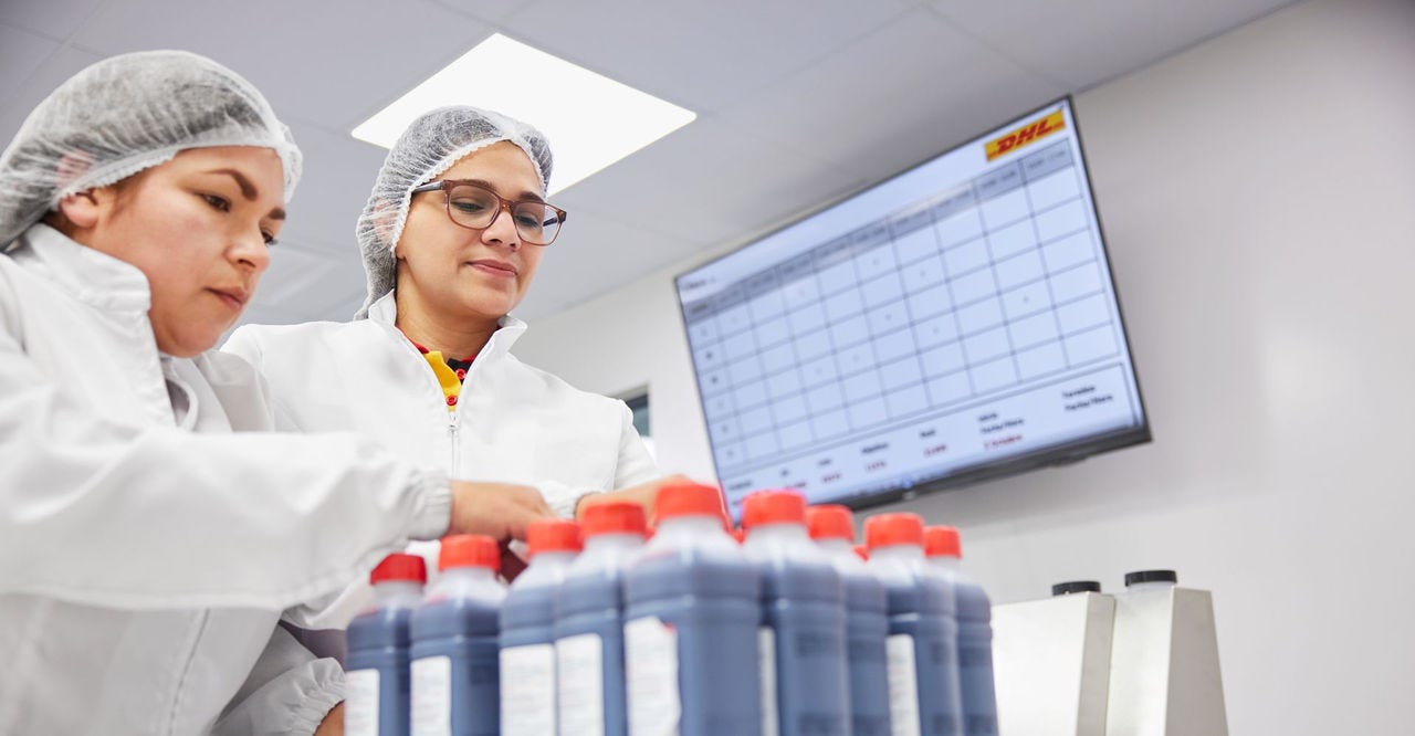 Two women wearing personal protective gear in a lab
