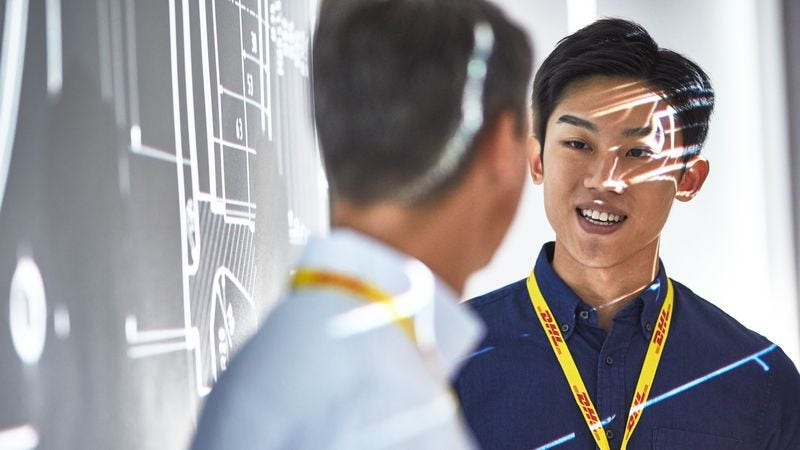 asian dhl employee having conversation with colleague