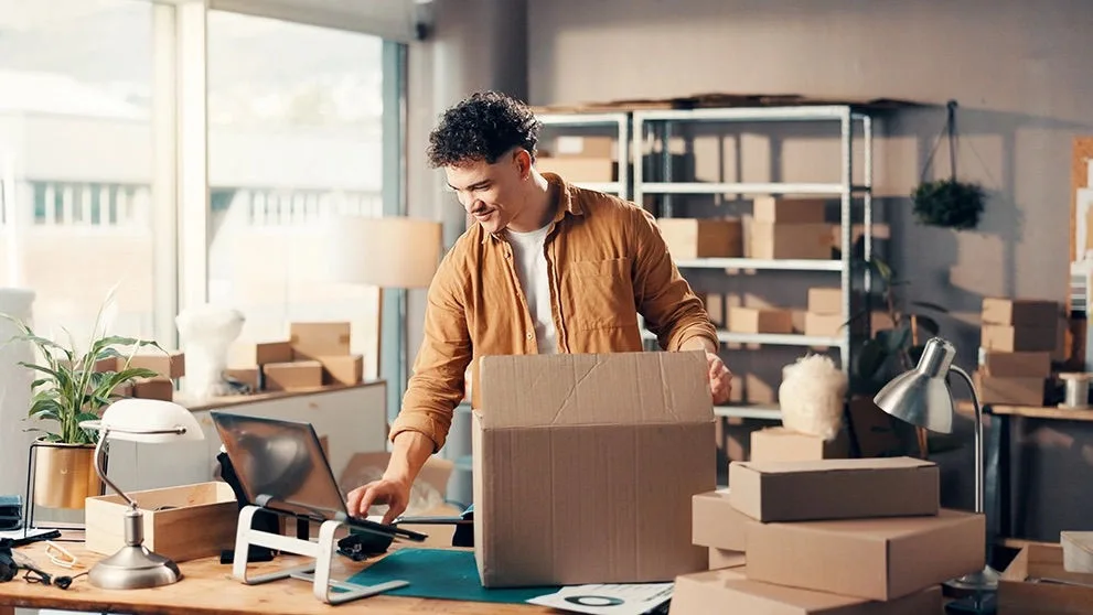 Empreendedor embalando produtos em caixas de papelão para envio