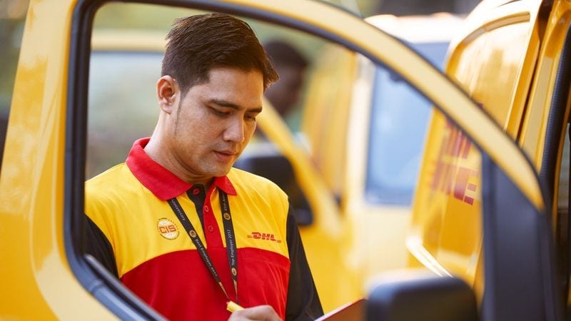 DHL Express employee writing on a clipboard, managing the paperwork for vanilla exports.