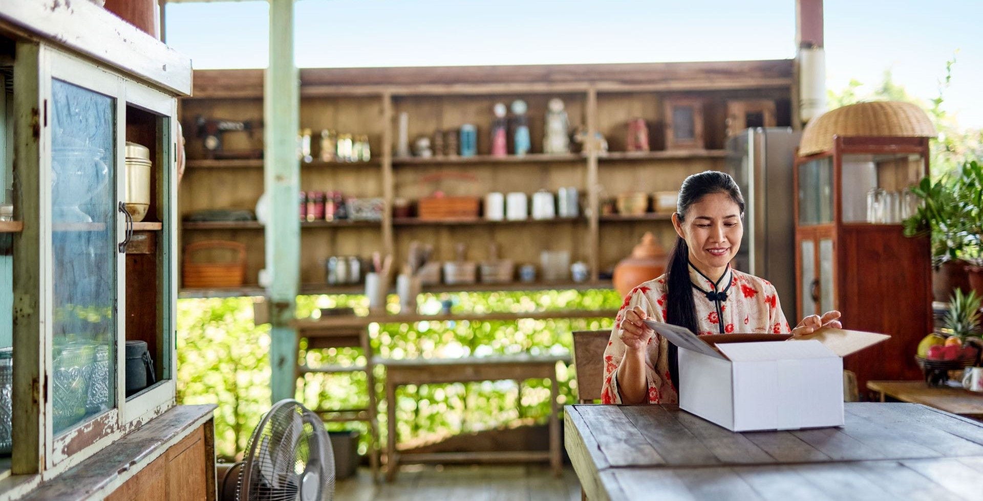 Asian woman opening a DHL package delivered to her