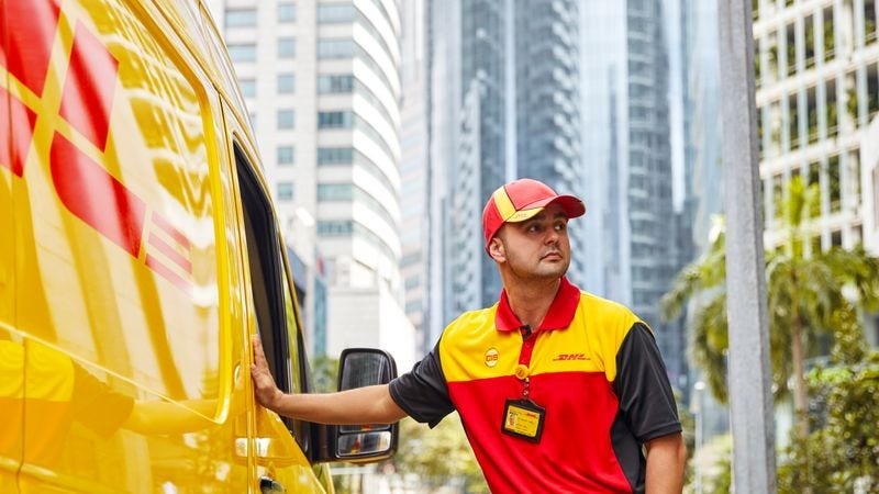 male dhl express employee by a dhl express van