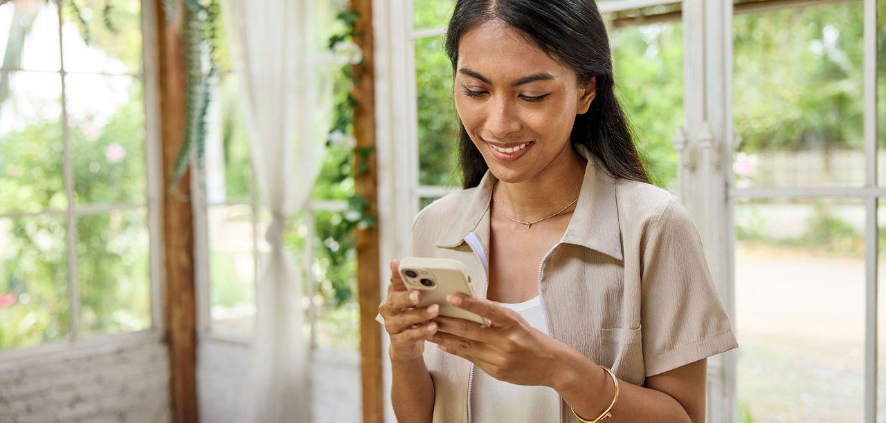 woman smiling and scrolling on a mobile phone