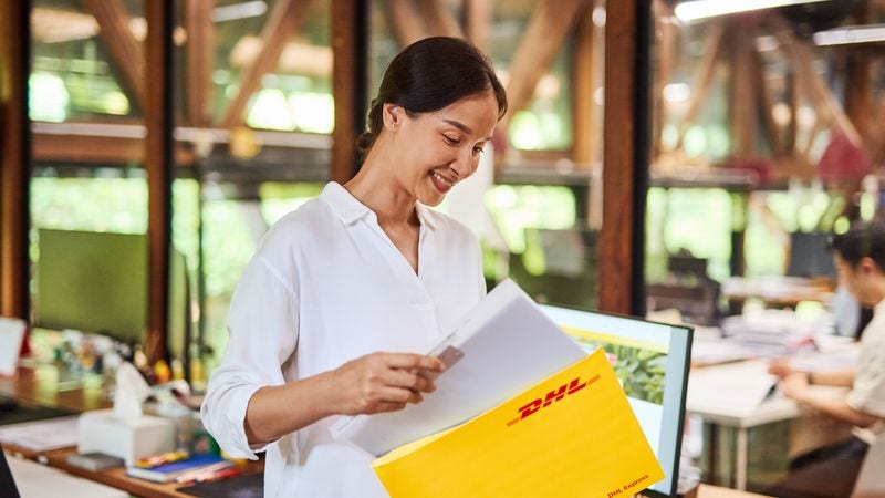 female customer pulling documents out of DHL express envelope