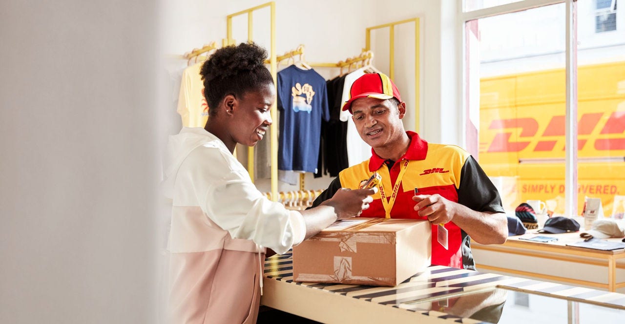 DHL Express employee assisting a customer with a package in a fashion retail store
