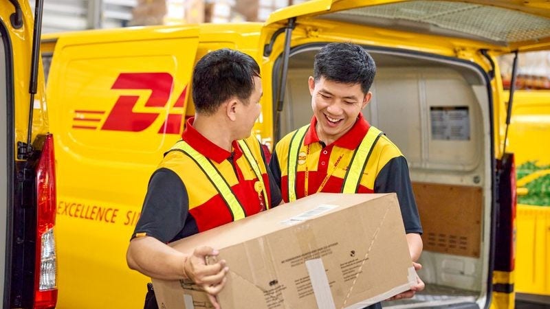 two-dhl-employees-handling-a-parcel