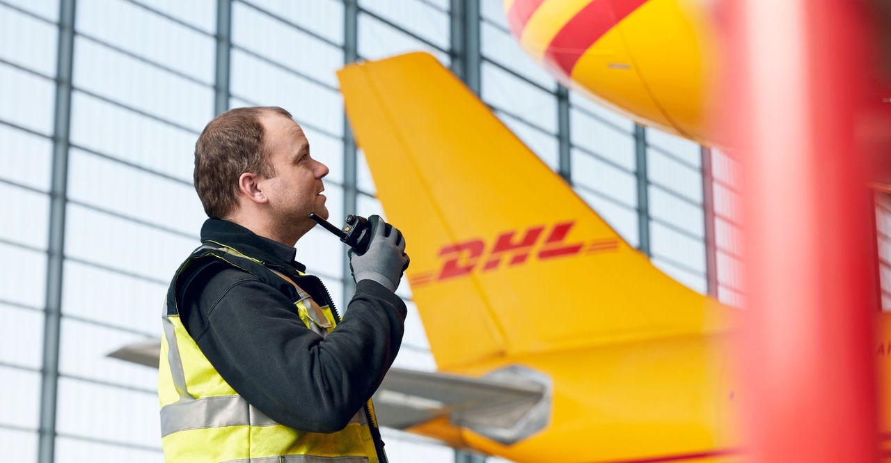 dhl employee by an aircraft using sustainable jet fuel