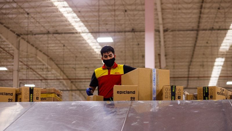 dhl worker comparing volumetric weight and actual weight of shipments