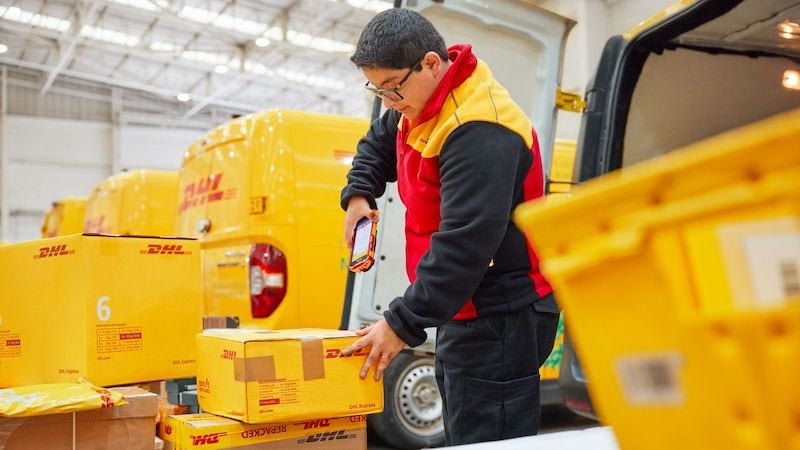 A DHL courier scans a shipment
