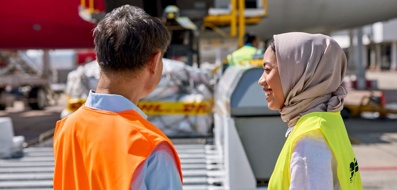 man and woman standing on a tarmac