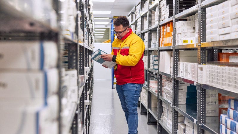 a male dhl employee checking products in a conditioned room