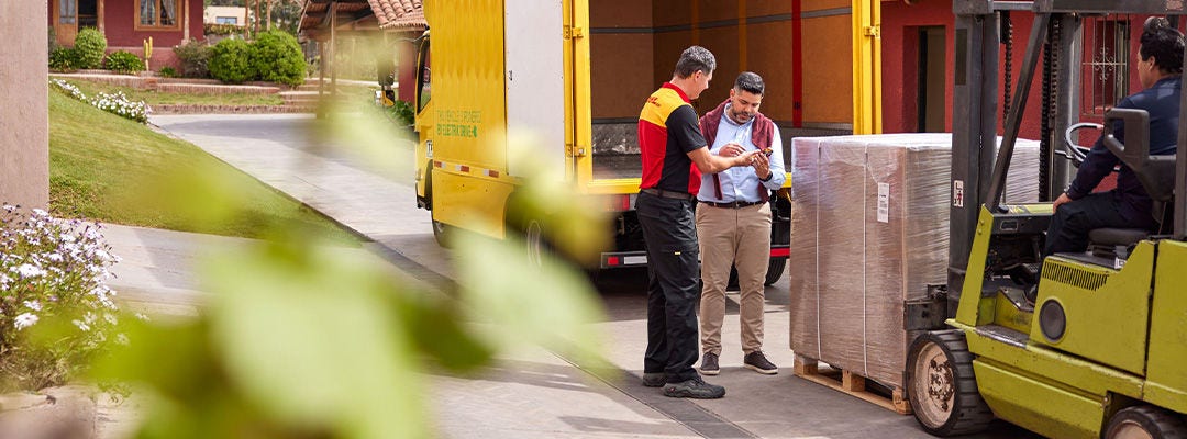 DHL courier and man standing in front of a pallet