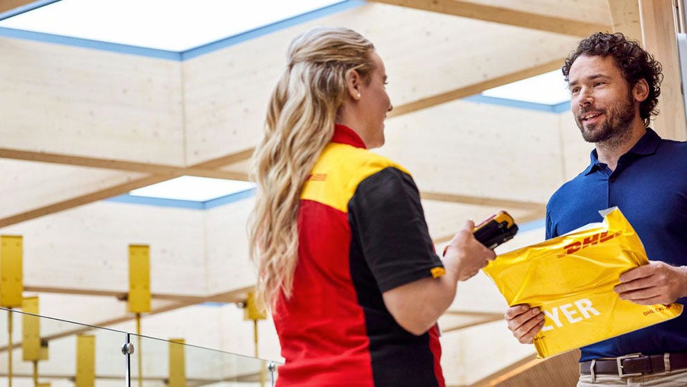 DHL delivery woman handing over a parcel to a man