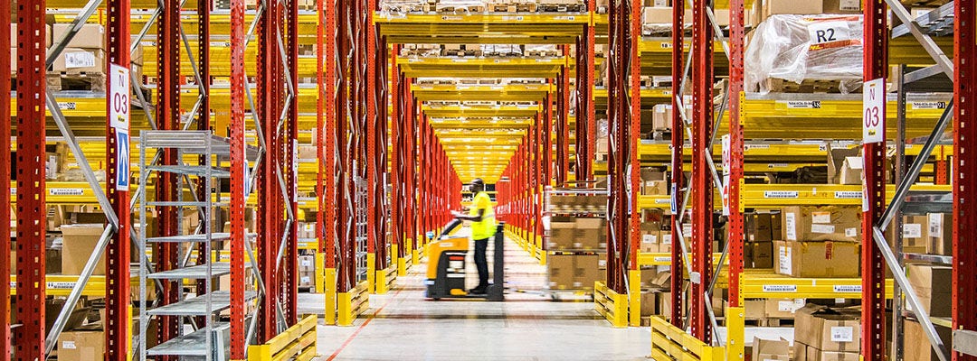 man riding forklift in a warehouse