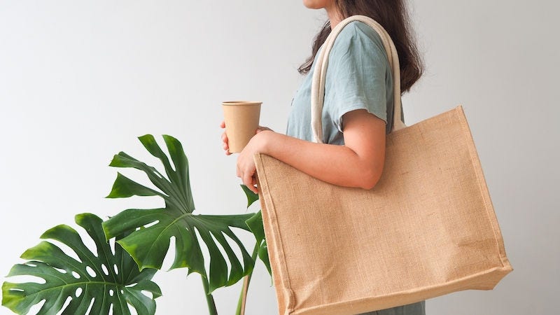 Woman holding  jute bag or sack bag on white background. Reusable shopping bag. Natural material. Zero waste. Plastic free. Eco friendly concept.