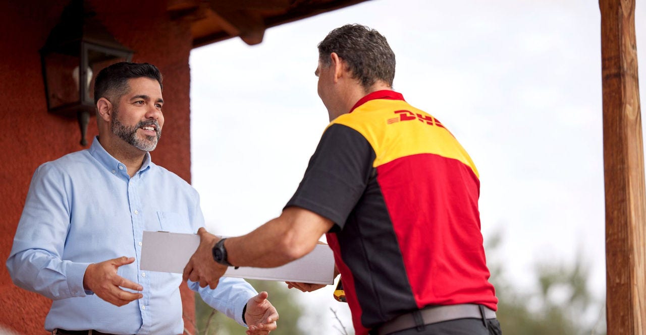 man from bahrain receiving a shipment from dhl express employee