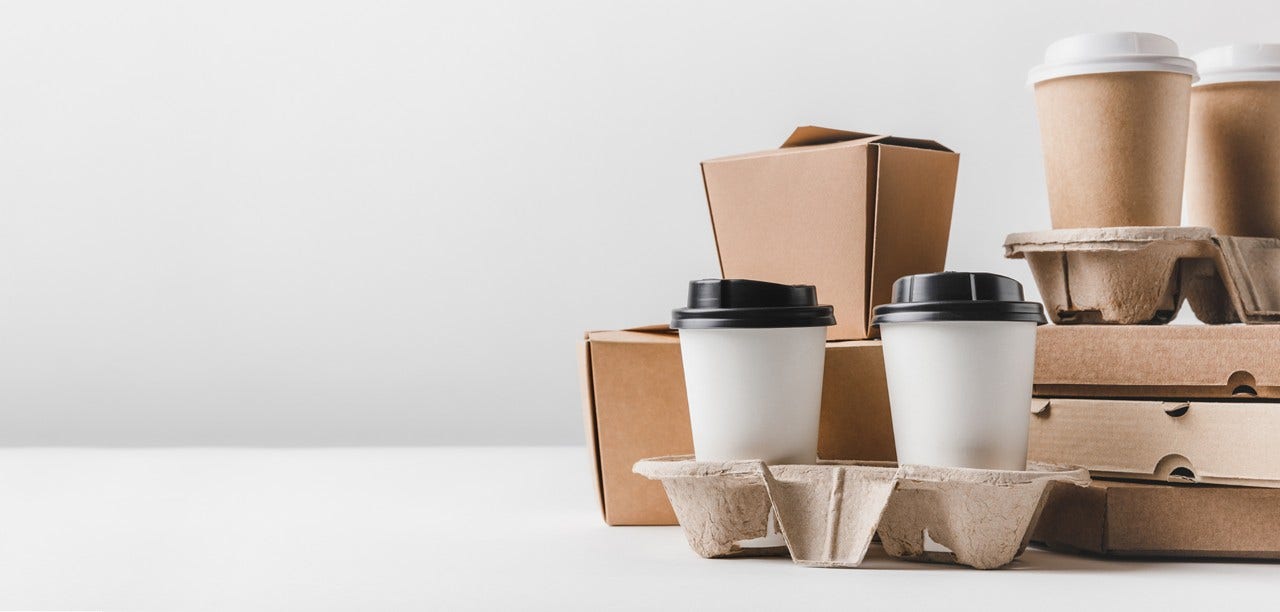 pizza boxes and coffee to go with noodles boxes on tabletop