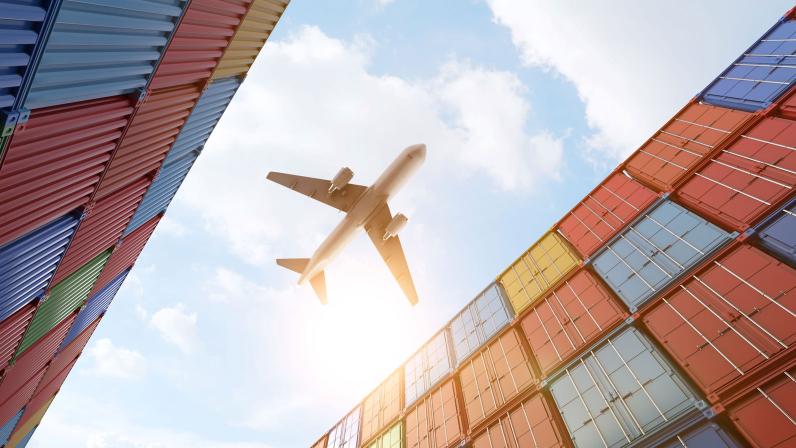airplane flying over shipping cargo