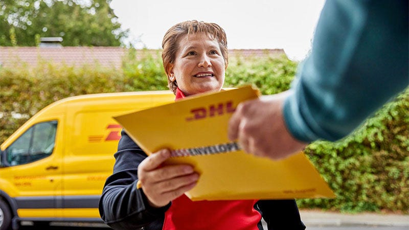 Livreuse de DHL remettant un colis à un homme