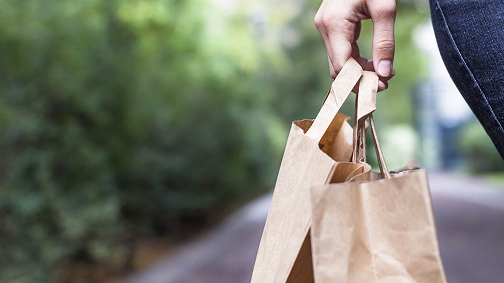 Girl doing ecological shopping with paper bags in hand