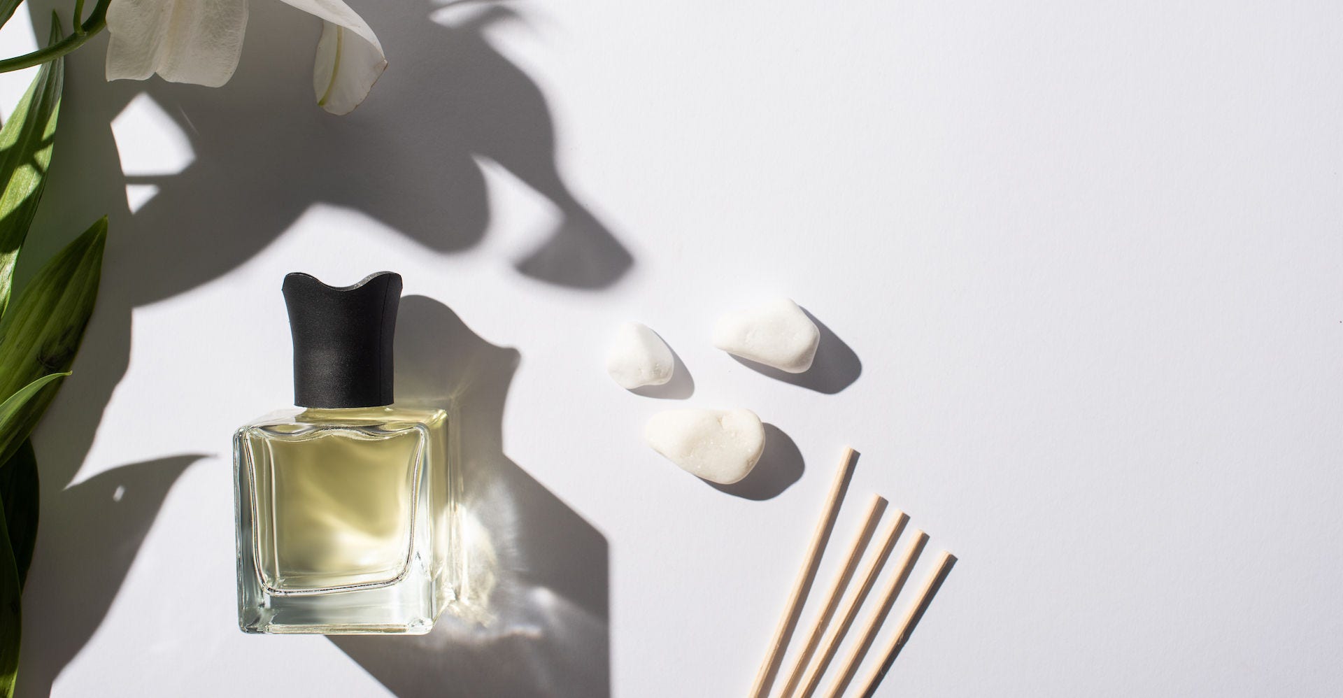 Top View of Aroma Sticks With Perfume in Bottle Near Stones And Lily Flower on White Background