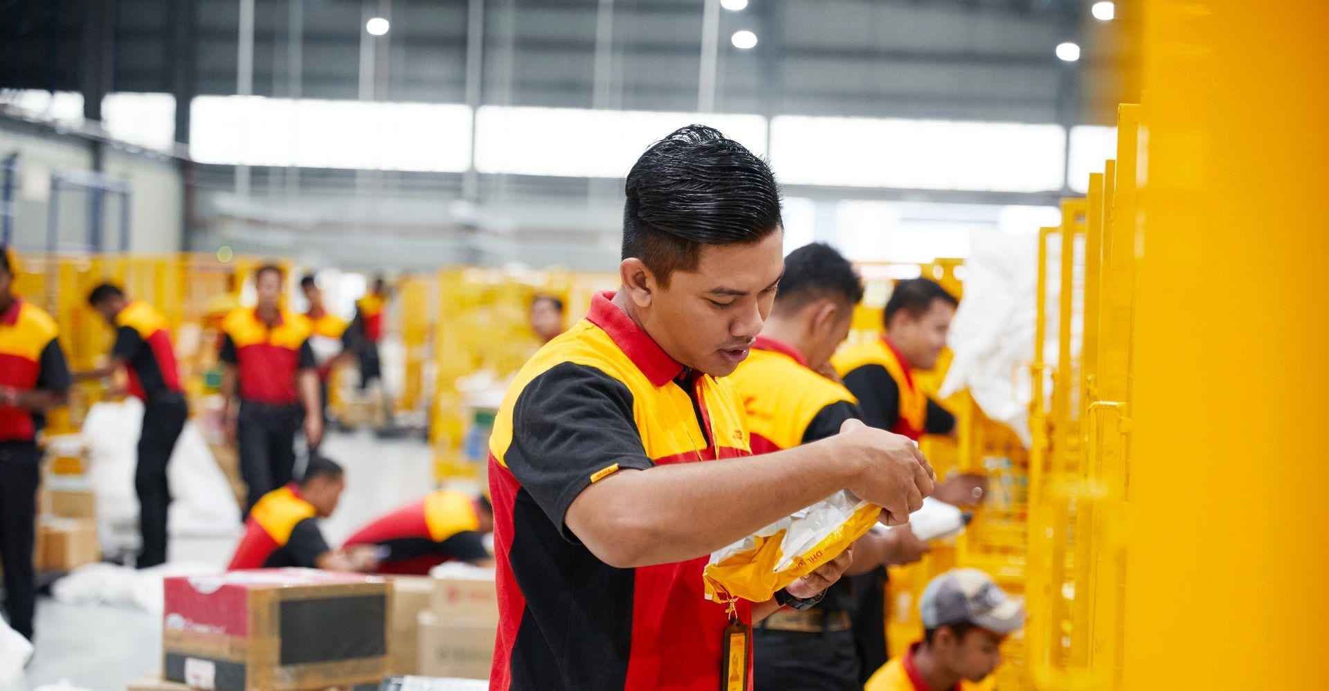 dhl express employee sorting parcel for supply chain efficiency