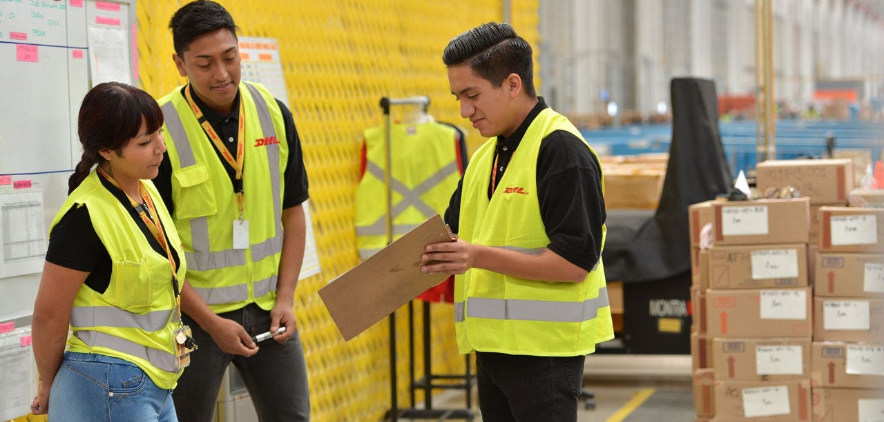 Equipe da DHL conferindo a documentação de uma carga no armazém, etapa que antecede a liberação da importação