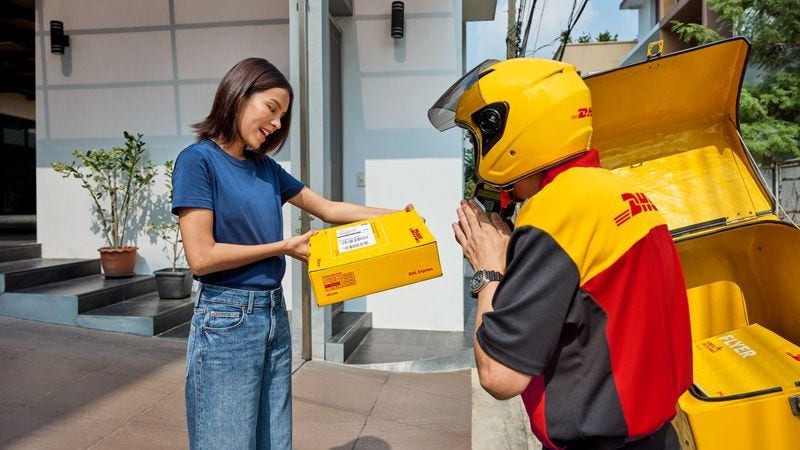 customer receiving a parcel from a male dhl express employee 