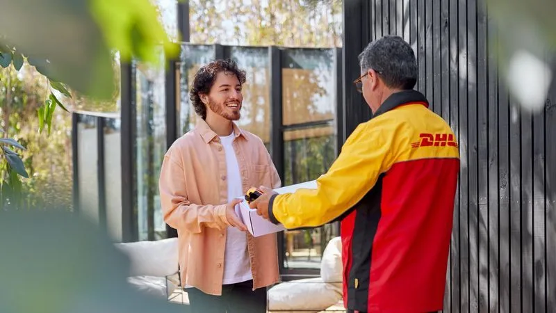 A young man receiving his parcels from a dhl express courier