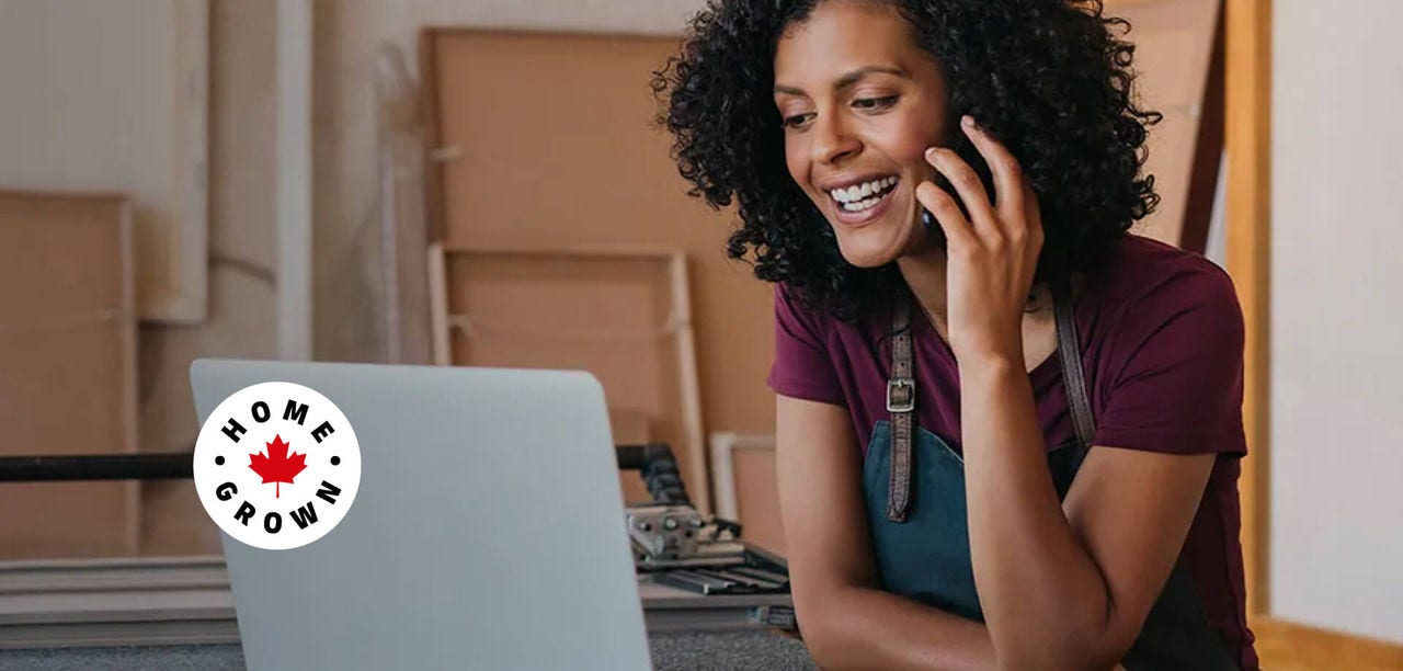 Woman talking on the phone while looking at her laptop