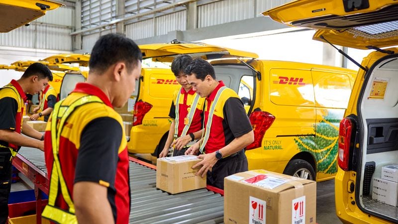 DHL Express staff carefully sorting and handling parcels, ensuring the secure process of shipping jewelry overseas