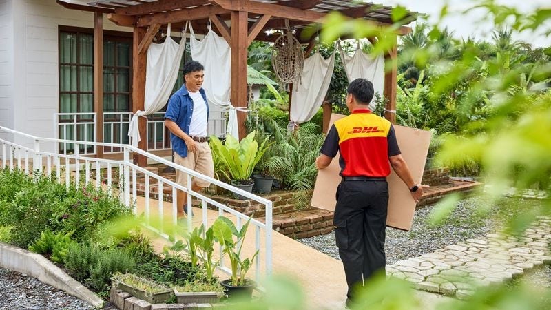 dhl express courier handing a fragile item over to a customer