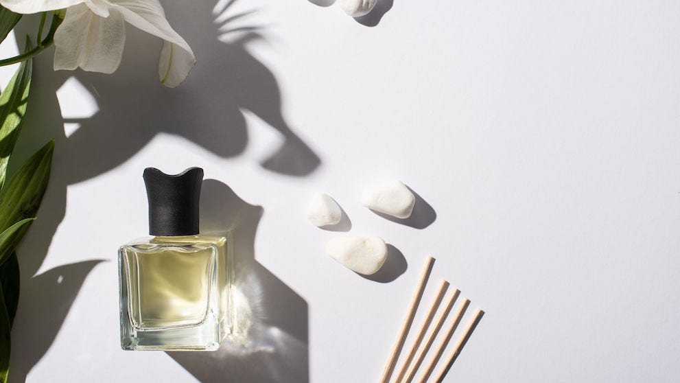 Top View of Aroma Sticks With Perfume in Bottle Near Stones And Lily Flower on White Background