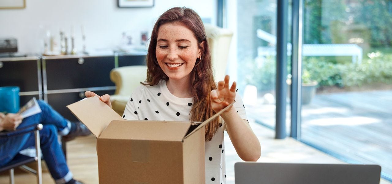 Girl opens parcel happily in a living room