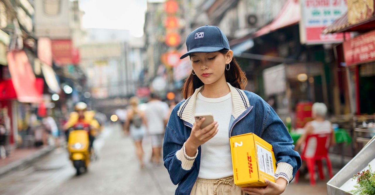 young female fashion entrepreneur collecting her DHL parcel