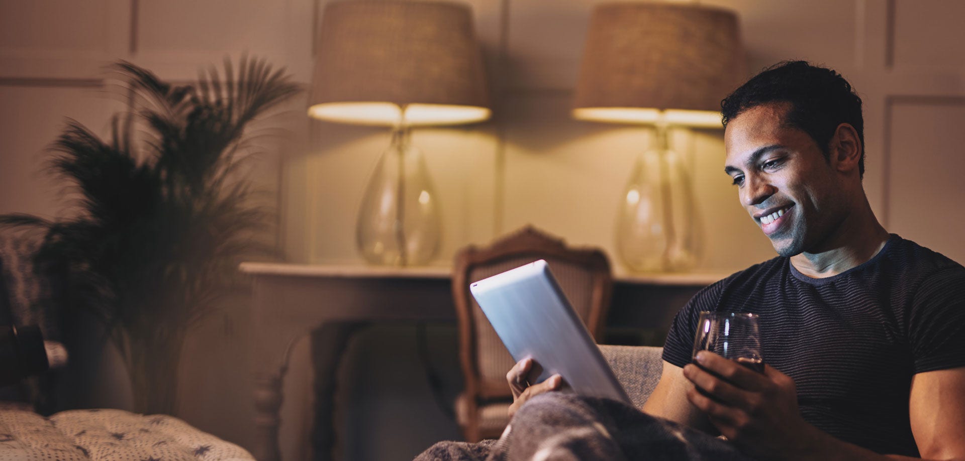 Man reading on a table with a glass of red wine