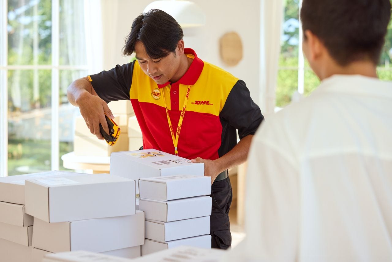 A male DHL employee is scanning parcels for pickup at a shop that sells products made with self-grown lemon essence. 