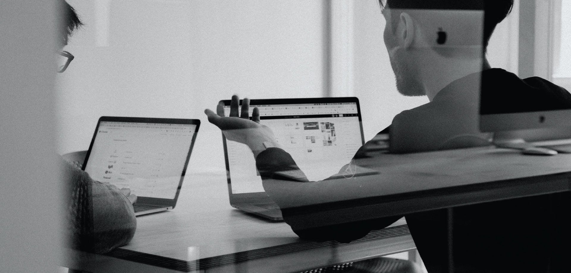 Dos ejecutivos observan una laptop en su oficina